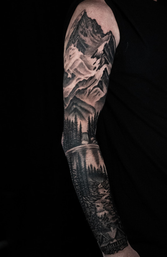 Full sleeve landscape tattoo with realistic mountains