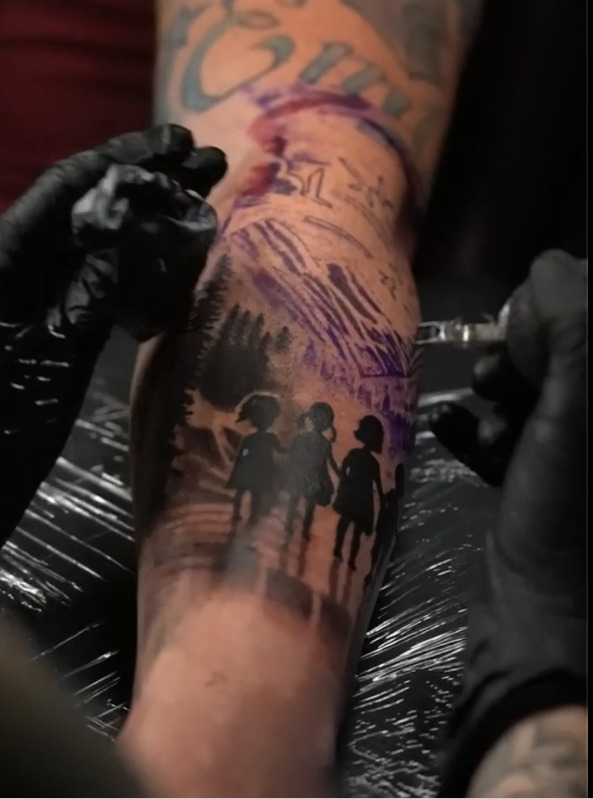 Tattoo in progress showing silhouettes of children
